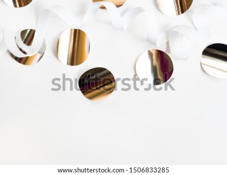 Shiny silver big confetti on white background. Festive modern minimalistic concept.