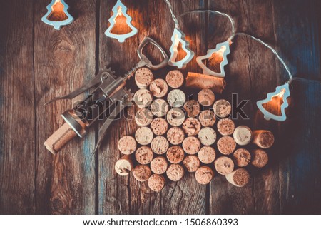Winter Christmas holidays background with wine corks, corkscrew and festive garland