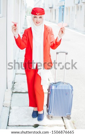 Female flight attendant  a Muslim woman in hijab. Muslim airline. The stewardess walking in the airport 