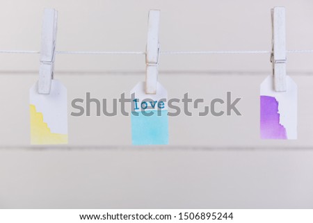 Love label  hang with rope and clothpin over white wood background