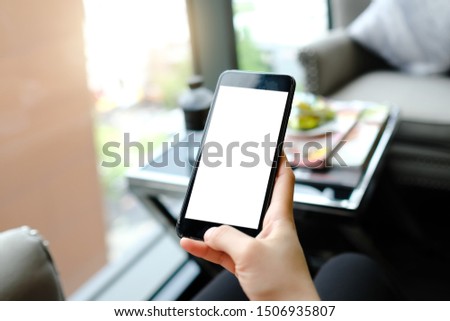Close up of woman using blank cell phone and credit card sending massages on the coffee shop. 