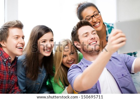 internet and technology concept - group of students taking selfie with tablet pc