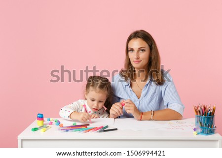 Woman child baby girl 4-5 years old draws are engaged in creativity. Mommy little kid daughter isolated on pastel pink background studio portrait. Mother Day love family parenthood childhood concept