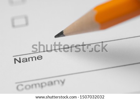 Filling in a form with a pencil, close up photo
