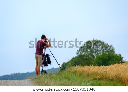 Nature photographer takes landscape photos in summer using a professional camera on a tripod