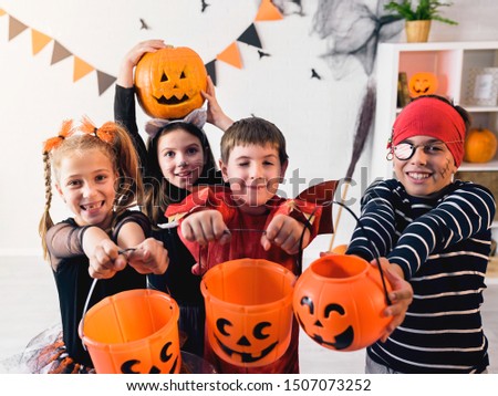Cute children in costumes trick-or-treating Halloween holiday concept