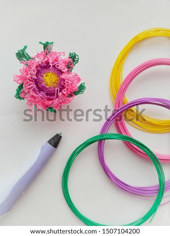 Ideas for creativity. New technology. Flower, 3D pen and skeins of plastic for pen on light background.