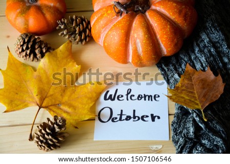 A note with Welcome October text on a rustic wooden table with Autumn decorations  Royalty-Free Stock Photo #1507106546