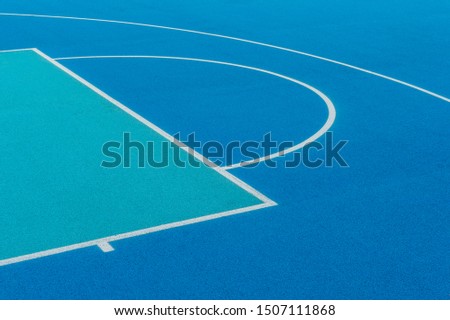 Abstract, blue background of newly made outdoor basketball court. Visible asphalt texture, freshly painted lines