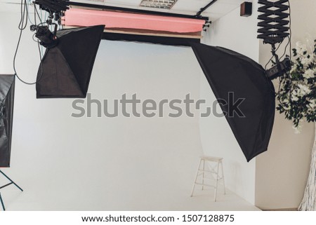 Photo of an empty photographic studio with modern lighting equipment. Empty space for your text or objects.