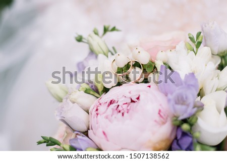 Picture with wedding rings lie on a bouquet of flowers