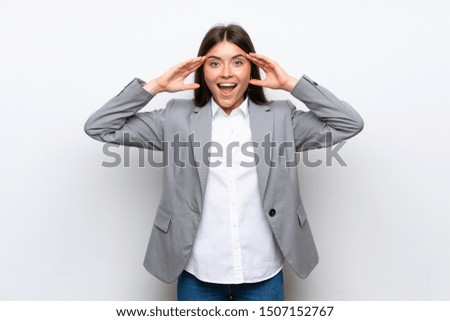 Young business woman over isolated white background with surprise expression