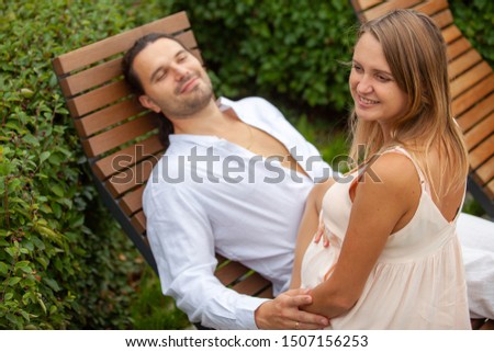 Young man and woman during pregnancy. Beautiful couple outdoors.