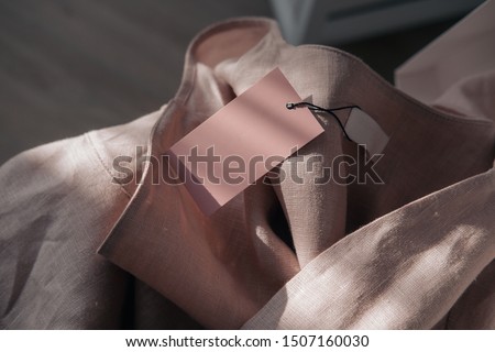 Pink linen dress with tag.  Branding mock up. Fashion blogging concept. Direct sunlight, lights and shadows photography.