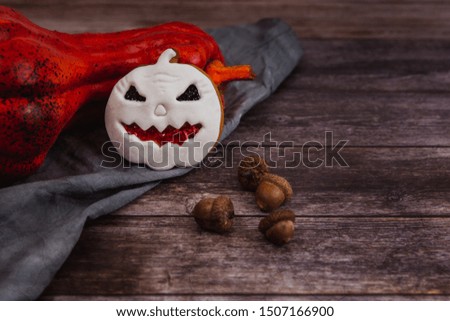 Hand painted gingerbread cookie scary Halloween old jack-o-lantern pumpkin on wooden background