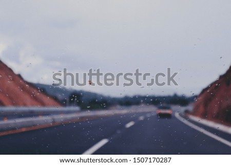 Rain drops in car window and highway