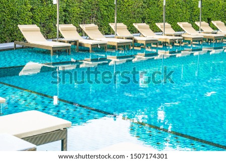 Umbrella and chair sofa around outdoor swimming pool in hotel resort for travel holiday vacation