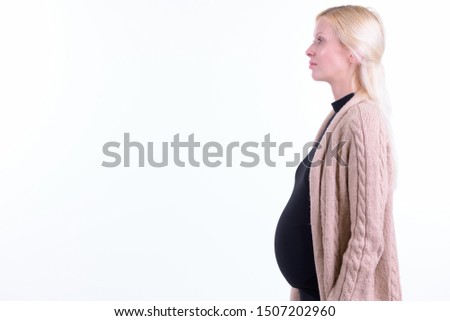 Profile view of young beautiful blonde pregnant woman