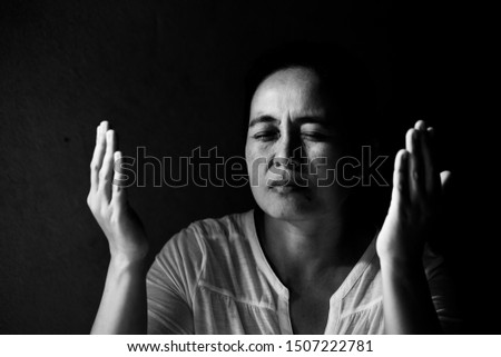 Portrait of a asian woman praying with her eyes closed