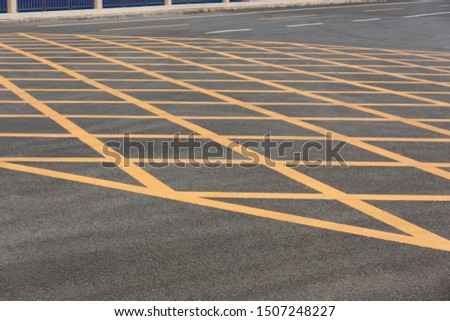 Low angle close-up of yellow asphalt cross grid on asphalt road