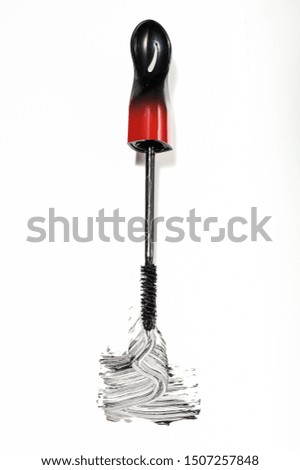 A mascara brush and the product on a white background