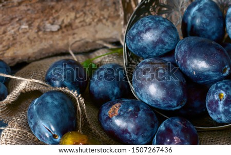 Garden plums on the table. Autumn harvest. Blue plums. Fresh plums on a wooden surface. Fresh plums on a wooden table background. Food Photo - Image