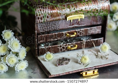 opened chest for jewellery surronded by flowers