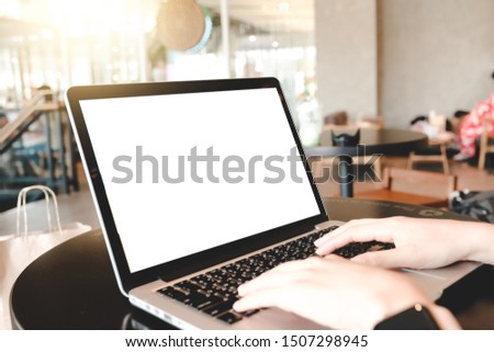 Close up of man using blank cell phone,laptop and credit card sending massages shopping online or reporting lost card, fraudulent transaction within the coffee shop.