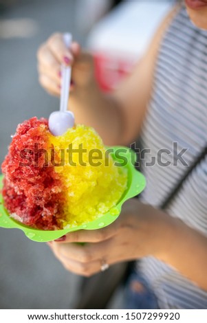 Woman eating a colorful Hawaiian shaved ice dessert