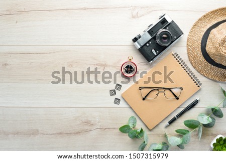 Travel accessories top view on wooden background with copy space. Adventure concept image with travel accessories.