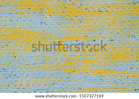 Surface painted blue with yellow paint strokes. Rough texture with different colors. Bright background for text or design