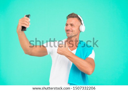 Selfie in gym concept. Healthy lifestyle. Gym aesthetics. Mature but still in good shape. Exercising in gym for better health. Man athlete taking selfie photo. Sportsman smartphone and headphones.