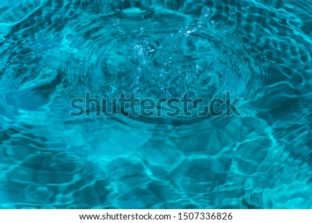 Water waves caused by raindrops falling. Water background blue