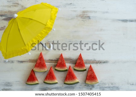Sliced ​​watermelon And a yellow umbrella Placed on a white old wooden floor with free space. For more messages
Summer concept