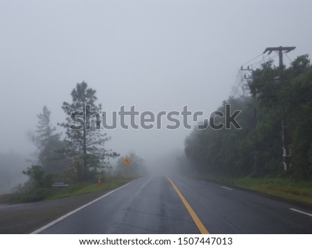 Blur image of the fog after rain.View through the windshield of cars on the asphalt road, wet after the rain, mountains, fog, mist,Trees and grass against a sky with clouds. Soft focus,Select focus