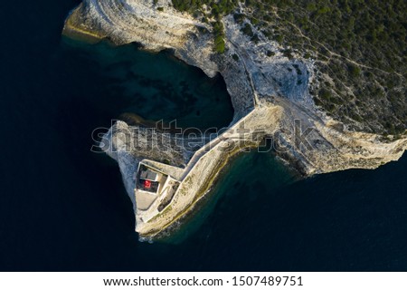 View from above, stunning aerial view of the lighthouse of Madonnetta at the entrance to the port of Bonifacio. Bonifacio is a commune at the southern tip of the island of Corsica, France.
