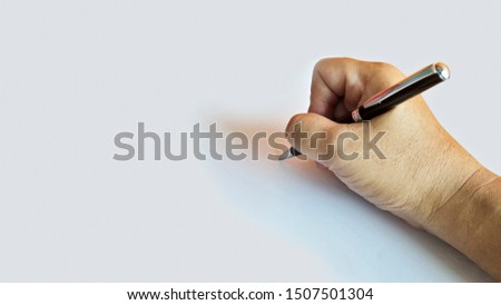 Isolated hand holding a black pen, written on white paper.