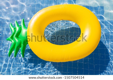 Pineapple float ring on the blue swimming pool