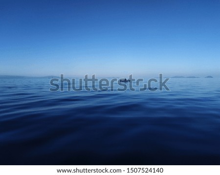 Deep blue sea with a fishing boat in a distant