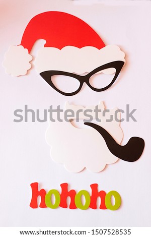 Red cap, black glasses, white beard and pipe. This is santa claus.