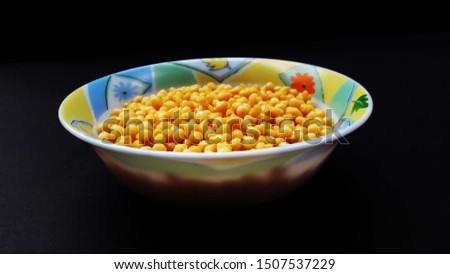 fresh and healthy deep fried gram flour balls in bowl isolated on black background