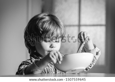 Kid eating. Little boy having breakfast in the kitchen. Cute child eating breakfast at home. Baby eating