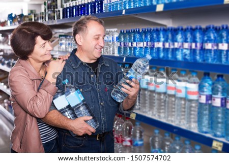 Mature couple buying a water at the grocery store