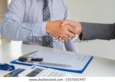 shaking hands, Car dealership provides advice about insurance details and car rental information and delivers the keys after signing the rental contract.