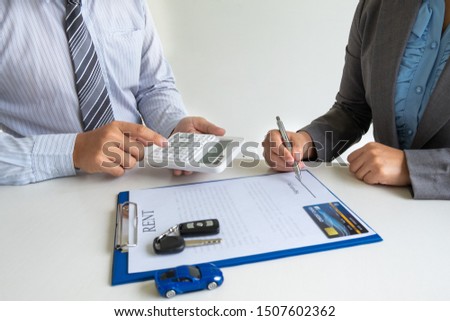 Car dealership provides advice about insurance details and car rental information and delivers the keys after signing the rental contract.