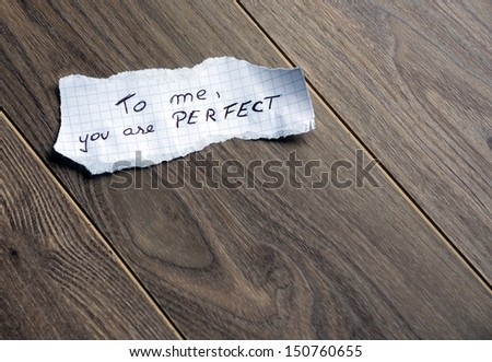 To me, you are Perfect - Hand writing text on a piece of paper on wood background with space for text