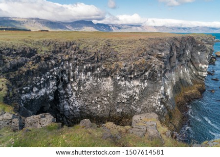 Beautiful scenic view of basalt rocks formation at the Atlantic coast of Arnarstapi at Snæfellsnes Peninsula in Iceland is very popular for photographers and tourists.