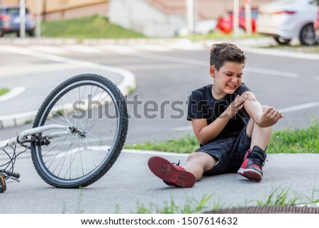 Boy injury hurts from falling bike, hurt on his arms, pain ache from falling off the bicycle Royalty-Free Stock Photo #1507614632