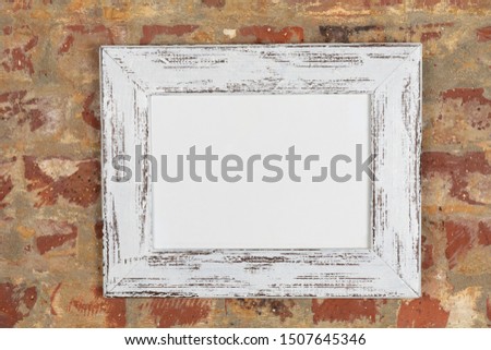 Blank framed picture hanging on a brick wall