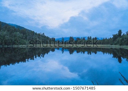 Lake Matheson nearby Franz Josef Glacier located in West Coast of Island New Zealand. A perfect scenery of mirror reflection of Mount Cook and Mount Tasman